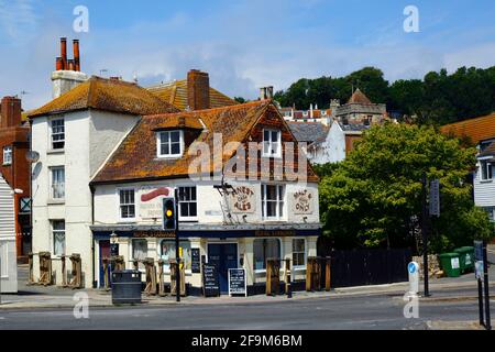 The Royal Standard pub on main A259 road at bottom of The Bourne in Old Town, St Clements church tower in background, Hastings, East Sussex, England Stock Photo