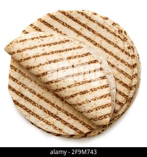 Folded tortilla on top of a stack of plain tortilla wraps with grill marks isolated on white. Top view. Stock Photo