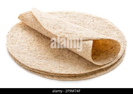 Rolled up tortilla on top of a stack of plain spelt and oat tortilla wraps isolated on white. Stock Photo