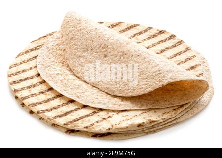 Folded spelt and oat tortilla on top of a stack of plain tortilla wraps with grill marks isolated on white. Stock Photo