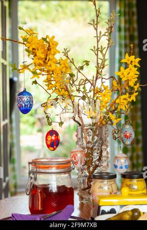 Hanging hand painted easter eggs from a branch as table decorations. Stock Photo