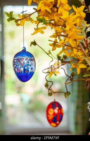 Hanging hand painted easter eggs from a branch as table decorations. Stock Photo