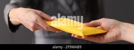 Womans hand giving envelope to another woman concept Stock Photo