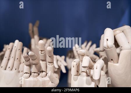 Dummy model wooden human hands gesture set on shelf on blue background close up. Mannequin hand collection closeup. Stock Photo
