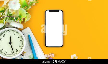 Mothers Day mockup with modern smartphone, blank white screen with copy space, flowers flat lay background Stock Photo