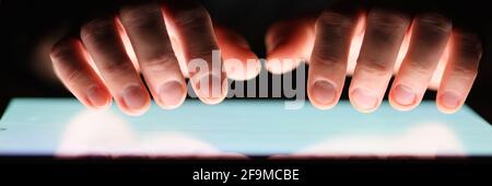 Male hands holding digital tablet at night close-up Stock Photo