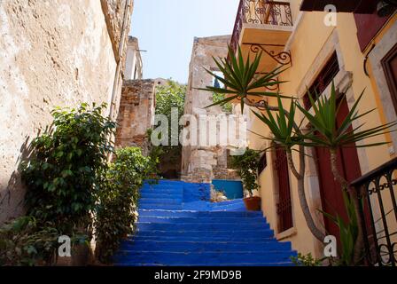Symi island, Greece Brightly painted staircase in the heart of the old town Traditional neo classical buildings line a steep, narrow alley   Dramatic Stock Photo