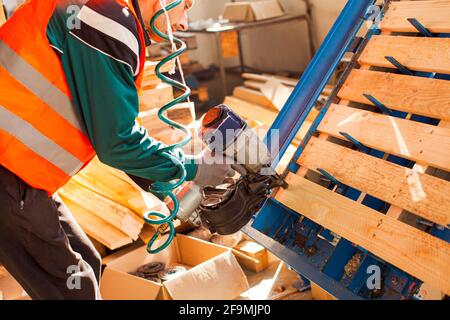 Professional furniture production factrory worker using pneumatic hammer Stock Photo