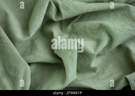 Green crumpled fabric texture background. Close up. Stock Photo