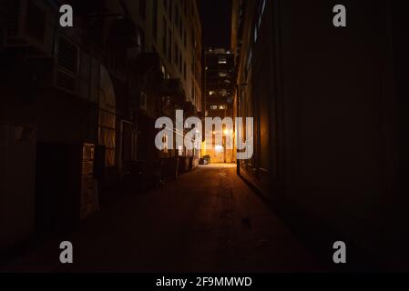 Dark and eerie urban city alley at night Stock Photo