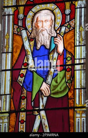 A Victorian stained glass window depicting Saint Andrew, holding the saltire cross he was crucified on. Saint Andrew is the patron saint of Scotland a Stock Photo