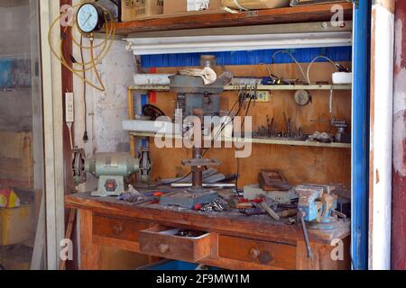 Small workshop bench with various tools by the side of a Chinese street.  Perfect for odd metalwork jobs. Stock Photo