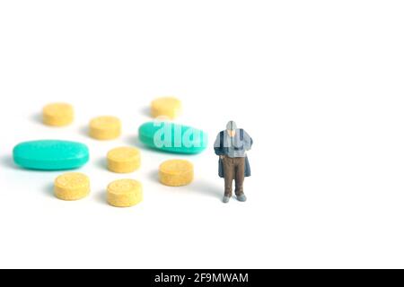The poor man with no money can't pay the medical bills, drug pill receipt. Miniature tiny people toys photography. isolated on white background. Stock Photo