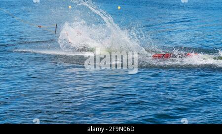 Man learning to wakeboard at a cable ski park and not succeeding as he falls off with a splash Stock Photo