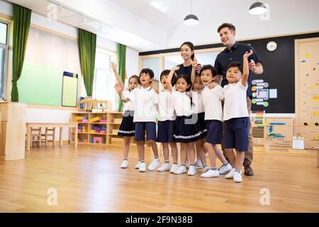 Teachers and children in classroom Stock Photo