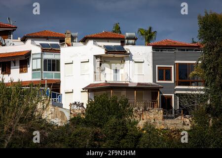 Two-storey residential area with small stone white houses with solar panels, air conditioning and sun shutters in a tropical hot country Stock Photo