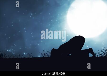 Silhouette of Muslim man in praying position (salat) with the night scene background Stock Photo