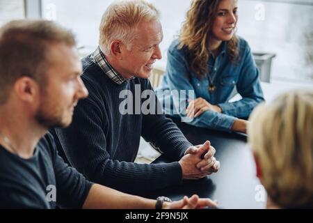 business group having a meeting in office boardroom. Team of male and female professionals discussing work in meeting. Stock Photo