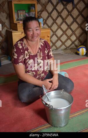 Woman inside the ger of a working herder family in the Gobi Desert who host  tourists and offer a taste of airag, fermented mare's milk. Stock Photo