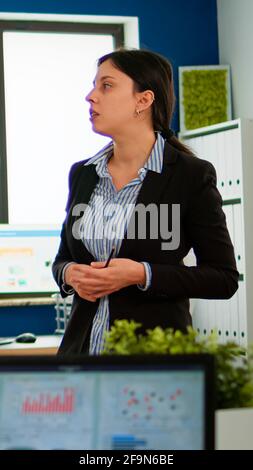 Professional entrepreneur discussing about project with her collegues, explaning company strategy during brainstorming. Diverse team working in professional startup financial office during conference Stock Photo