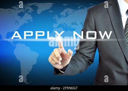 Businessman hand touching APPLY NOW word on virtual screen Stock Photo