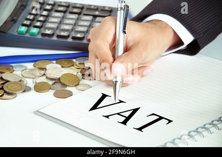 Hand with pen pointing to VAT (or Value Added Tax) sign on the paper - commercial & taxation concept Stock Photo