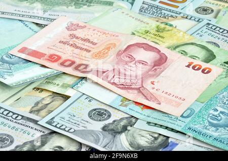 Money in multi currencies - 100 Thai Baht bill on top Stock Photo