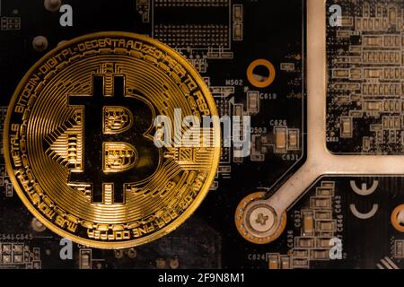 Bitcoins lie on the video card, concept of mining. Electronic virtual money for web banking and international network payment. Symbol of crypto currency. High quality photo Stock Photo