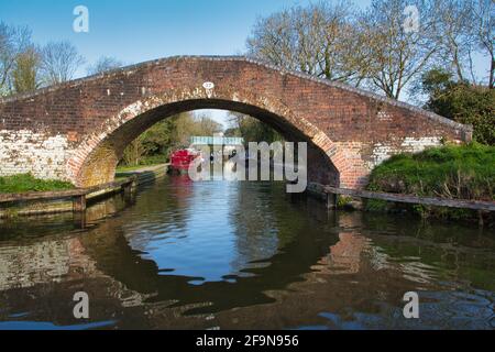 View through the bridge at Kingswood Junction, where the Stratford Canal meets the Grand Union canal. The bridge is reflected in the water. Stock Photo