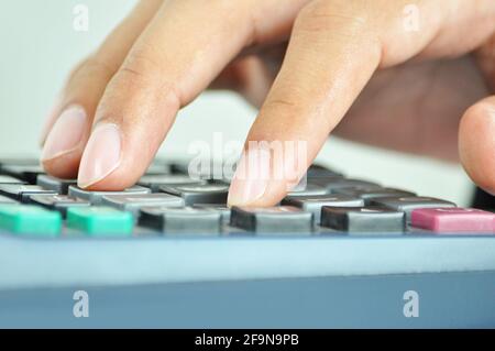 Finger pressing on calculator keypad - close up Stock Photo