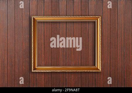 Golden picture frame on wooden wall Stock Photo