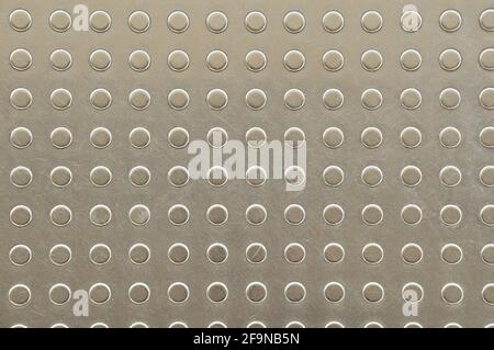 Dots on metal plate as tactile paving or signal for blind people on footpath or platform Stock Photo