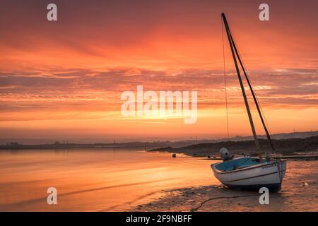 Appledore, North Devon, England. Tuesday 20th April 2021. UK Weather. A beautiful predawn sky glows over a tranquil River Torridge estuary as the incoming tide creeps along the shoreline at Appledore. Today hazy sunshine and light winds are forecast for the coast of North Devon. Credit: Terry Mathews/Alamy Live News Stock Photo