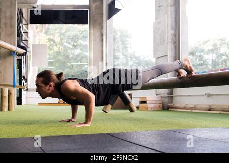 sporty man trains in the gym doing push-ups, sport and active lifestyle concept Stock Photo