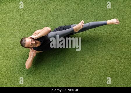 top view of a sporty man training in the gym doing crunches on the floor, sport and active lifestyle concept Stock Photo