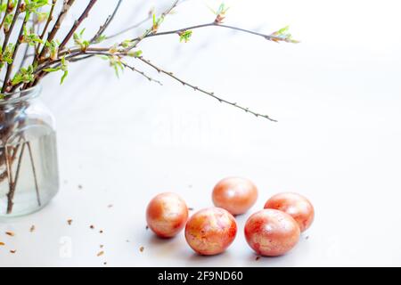 Five eggs on a white table. Easter light still life with spring twigs with delicate greens Stock Photo