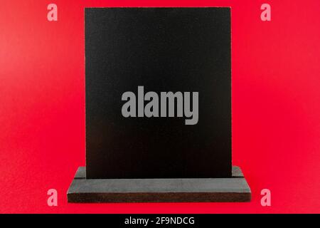 Wooden chalkboard mockup or wooden frame on red surface. Dark information board, stand template, sign board for your design or menu in cafe Stock Photo