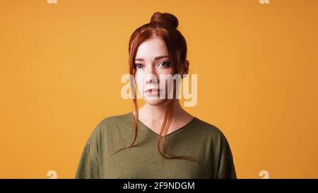 portrait of pretty young woman with red hair bun and curtain bangs Stock Photo