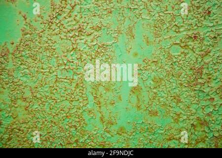 Green metal texture with patches of rust steel on its surface, taken outdoor. The pattern of an old painted metal surface. Rusty metal, peeling paint Stock Photo