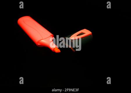 Red marker pen and cap isolated on black close-up Stock Photo