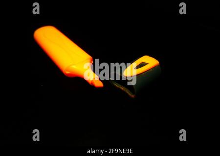 Red marker pen and cap isolated on black close-up Stock Photo