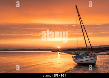Appledore, North Devon, England. Tuesday 20th April 2021. UK Weather. A beautiful sunrise over a tranquil River Torridge estuary as the incoming tide creeps along the shoreline at Appledore. Today hazy sunshine and light winds are forecast for the coast of North Devon. Credit: Terry Mathews/Alamy Live News Stock Photo