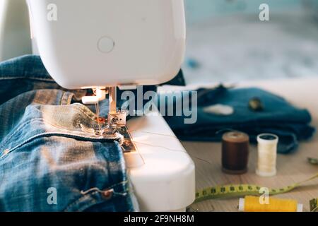 Sewing machine sewing accessories scissors thread buttons for repairing or sewing clothes on a desktop light background selective focus. Copy space pl Stock Photo