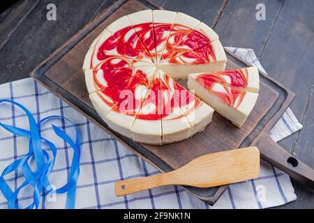 New York Style Cheesecake with Strawberries on a cutting board. Close up.  Stock Photo