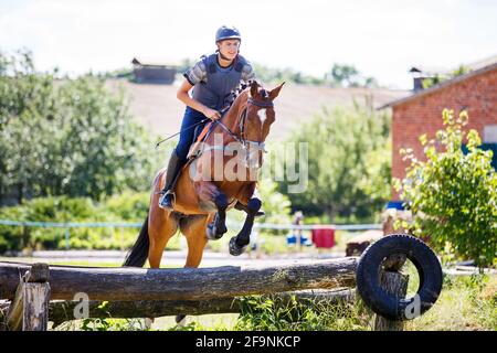 Rider jumps horse over log on cross-country course Stock Photo