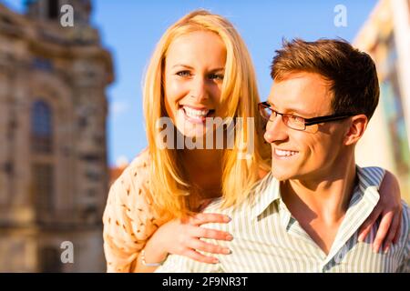 Woman jumping on the back of a man piggyback being happy in the sunshine Stock Photo