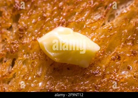 Close up of melting butter on a slice of tasty bread toast Stock Photo