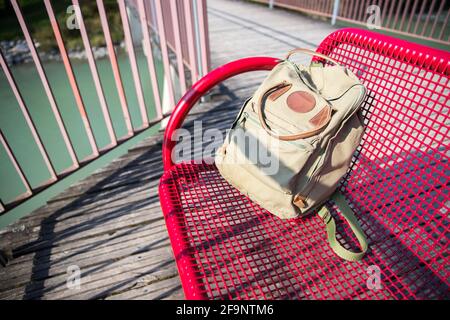 Vintage backpack is lying on red bench Stock Photo