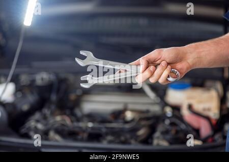 Close-up photo of wrenches in mans hand Stock Photo