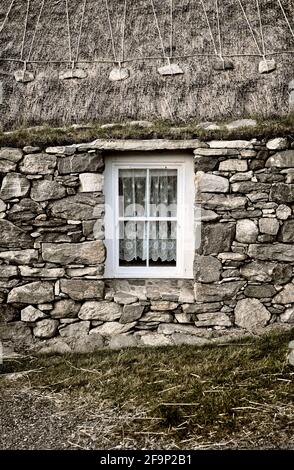 Blackhouse Village. Restored crofting fishing township of Garenin, Na Gearrannan. Lewis, Outer Hebrides.  Lived in until 1974. Thatch and croft window Stock Photo